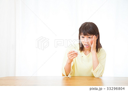 体温計を持つ女性　頭痛　頭が痛い　ネガティブイメージ　女性　ポートレート　20代　30代 33296804