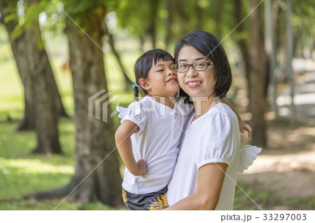 Asian little daughter is kissing her mother Asian little daughter is kissing her mother 33297003