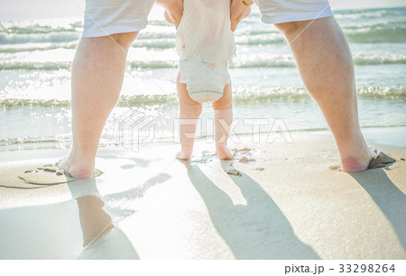 Close up of father and little baby feet on beach 33298264