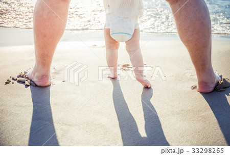 Close up of father and little baby feet on beach 33298265