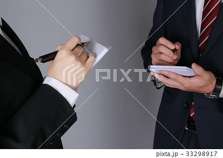 メモを取り合うビジネスマン＆ビジネスウーマン（手元アップ） 33298917