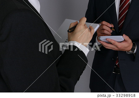 メモを取り合うビジネスマン＆ビジネスウーマン（手元アップ） 33298918