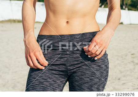 Close-up flat women's belly on the beach Close-up flat women's belly on the beach 33299076