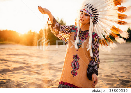 Woman in suit of American Indian on sunset Woman in suit of American Indian on sunset 33300556