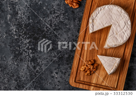 Camembert cheese on cutting board. Camembert cheese on cutting board. 33312530