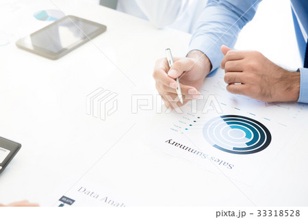 Businessman holding pen while reading graph 33318528