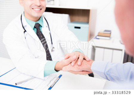 Doctor holding senior male patient hand 33318529