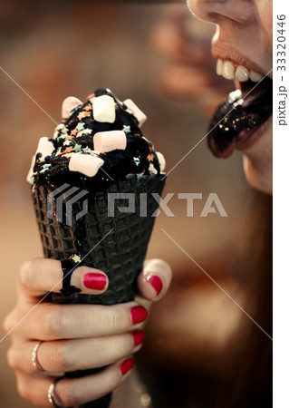 Woman licks with black tongue trend cone of Woman licks with black tongue trend cone of 33320446
