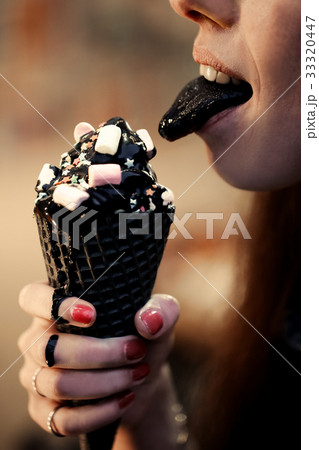 Woman licks with black tongue trend cone of Woman licks with black tongue trend cone of 33320447