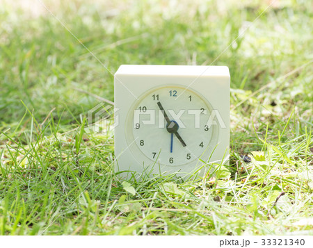 芝生の上の四角いシンプルな白い時計 4:55 芝生の上の四角いシンプルな白い時計 4:55 33321340