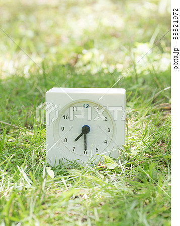 芝生の上の四角いシンプルな白い時計　 7:30 33321972