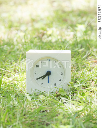 芝生の上の四角いシンプルな白い時計　7:40 33321974