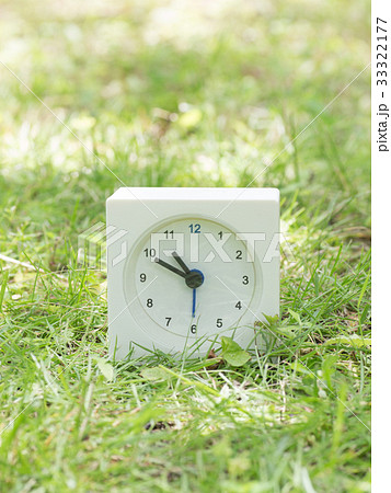 芝生の上の四角いシンプルな白い時計　10:50 33322177