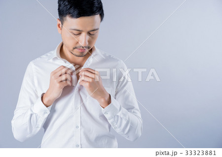 The man is wearing the white shirt on gray background. 33323881