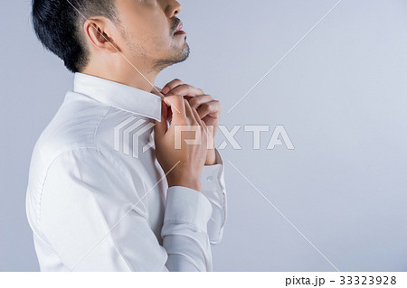 A picture of a businessman holding the collar of his shirt A picture of a businessman holding the collar of his shirt 33323928