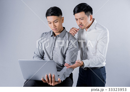 A picture of two businessmen looking at a laptop 33323953