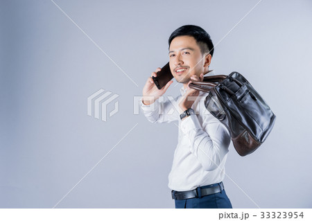 A picture of a man holding a handbag and talking on phone A picture of a man holding a handbag and talking on phone 33323954