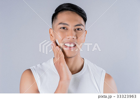 a man is applying shaving cream on his face and smiling a man is applying shaving cream on his face and smiling 33323963