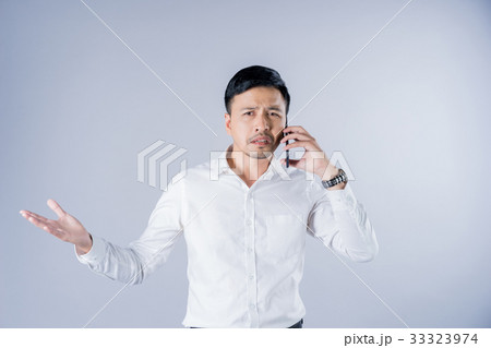 a portrait of an un happy businessman is talking on a phone a portrait of an un happy businessman is talking on a phone 33323974