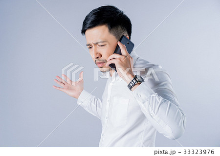 a businessman is talking to someone over the phone 33323976