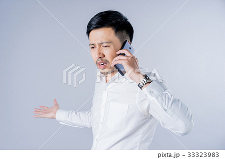 a businessman is talking on a phone with angry feeling a businessman is talking on a phone with angry feeling 33323983