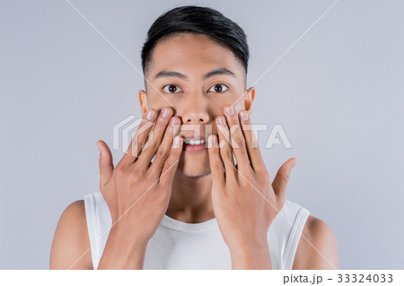 photo of asian young man with hands on his face photo of asian young man with hands on his face 33324033