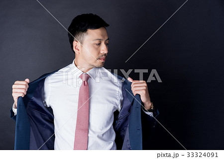 asian businessman on suit is posing on black background asian businessman on suit is posing on black background 33324091