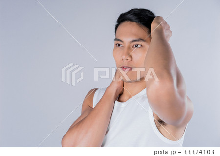 a young man is touching his face on gray background a young man is touching his face on gray background 33324103