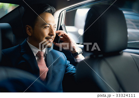 Asian handsome businessman on call in car, smiling 33324111