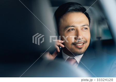 a businessman is calling and smiling in car 33324120