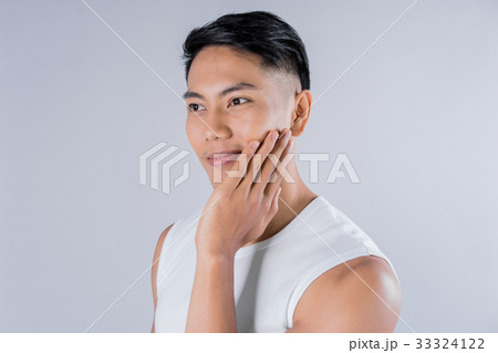 a young man is touching his face and smiling 33324122