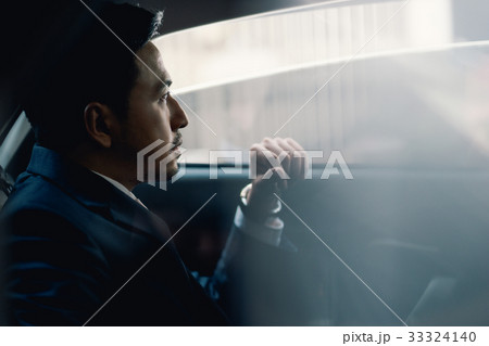 A photo of businessman sitting and looking outside from the car 33324140