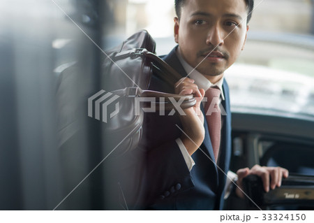 A photo of businessman wearing suit and holding his bag A photo of businessman wearing suit and holding his bag 33324150