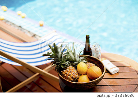 Closeup of tropical fruits in wooden basket by the poolside Closeup of tropical fruits in wooden basket by the poolside 33326036