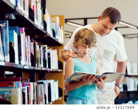Boy and his father in library 33327689