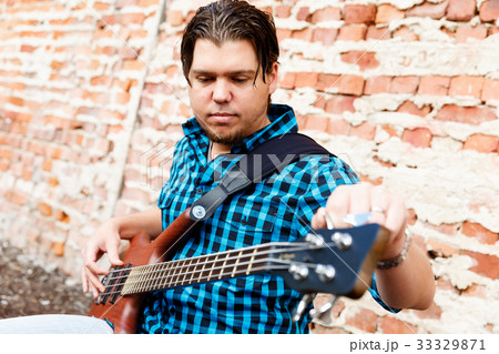 Tuning his guitar 33329871