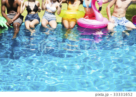 Group of diverse friends enjoying summer time by the pool with inflatable tubes Group of diverse friends enjoying summer time by the pool with inflatable tubes 33331652