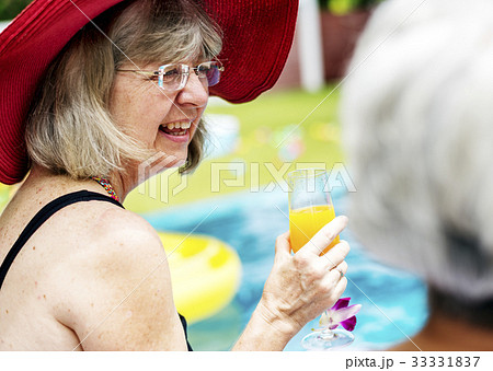 Closeup of senior caucasian woman with juice by the pool 33331837