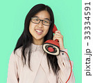 Asian girl talking by phone studio portrait 33334591