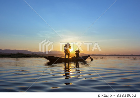Silhouette of  fisherman setting fishing net 33338652