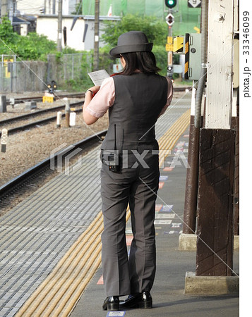 夕日に照らされる凛々しい女性の駅員さんの写真素材