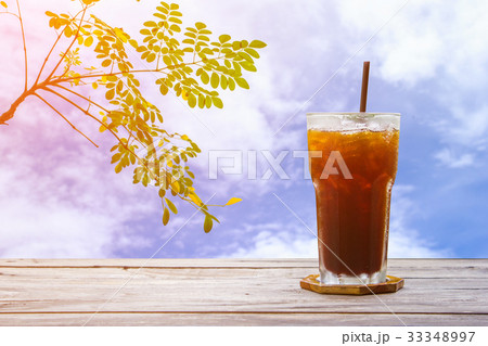 Ice coffee or cola on wood table with tree 33348997