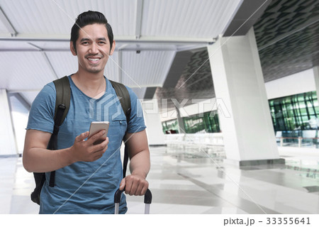 Asian traveler with backpack using cellphone 33355641