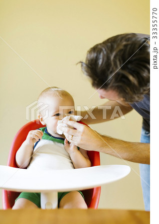 Father assisting son (12-17 months) to blow nose Father assisting son (12-17 months) to blow nose 33355770