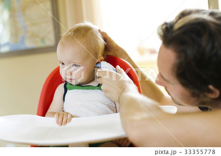 Father measuring son's (12-17 months) temperature Father measuring son's (12-17 months) temperature 33355778