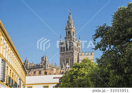 Spain, Andalusia, Seville, La Giralda bell tower of Seville cathedral with tree top in foreground Spain, Andalusia, Seville, La Giralda bell tower of Seville cathedral with tree top in foreground 33355951