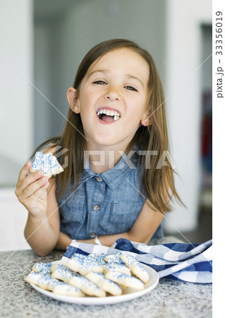 Portrait of girl (6-7) eating cookies Portrait of girl (6-7) eating cookies 33356019