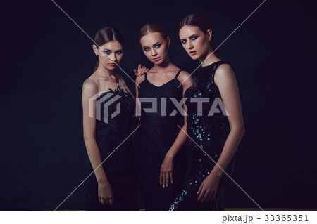 Beautiful women in black cocktail dresses on a 33365351