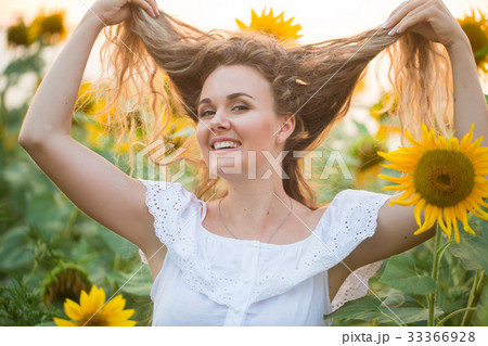 Young woman in a field of sunflowers. sunset light Young woman in a field of sunflowers. sunset light 33366928