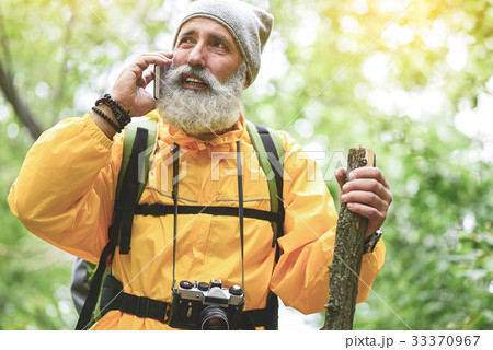 Thoughtful old man communicating on smartphone in 33370967